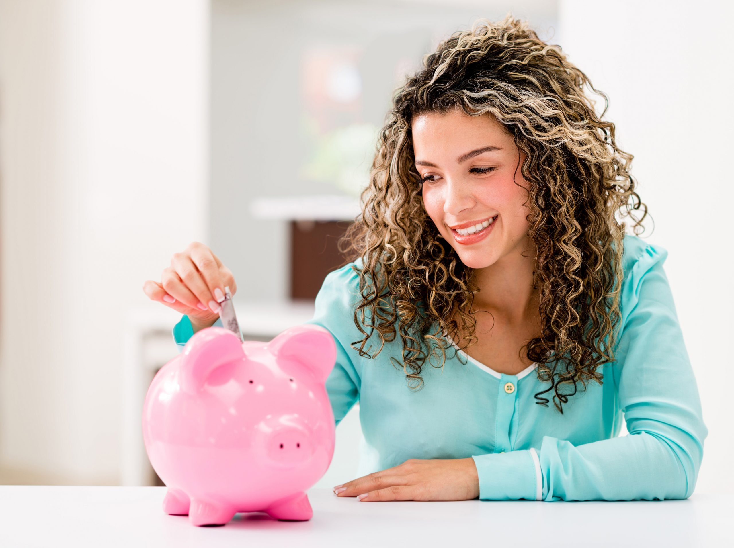 Woman putting money into a piggy bank