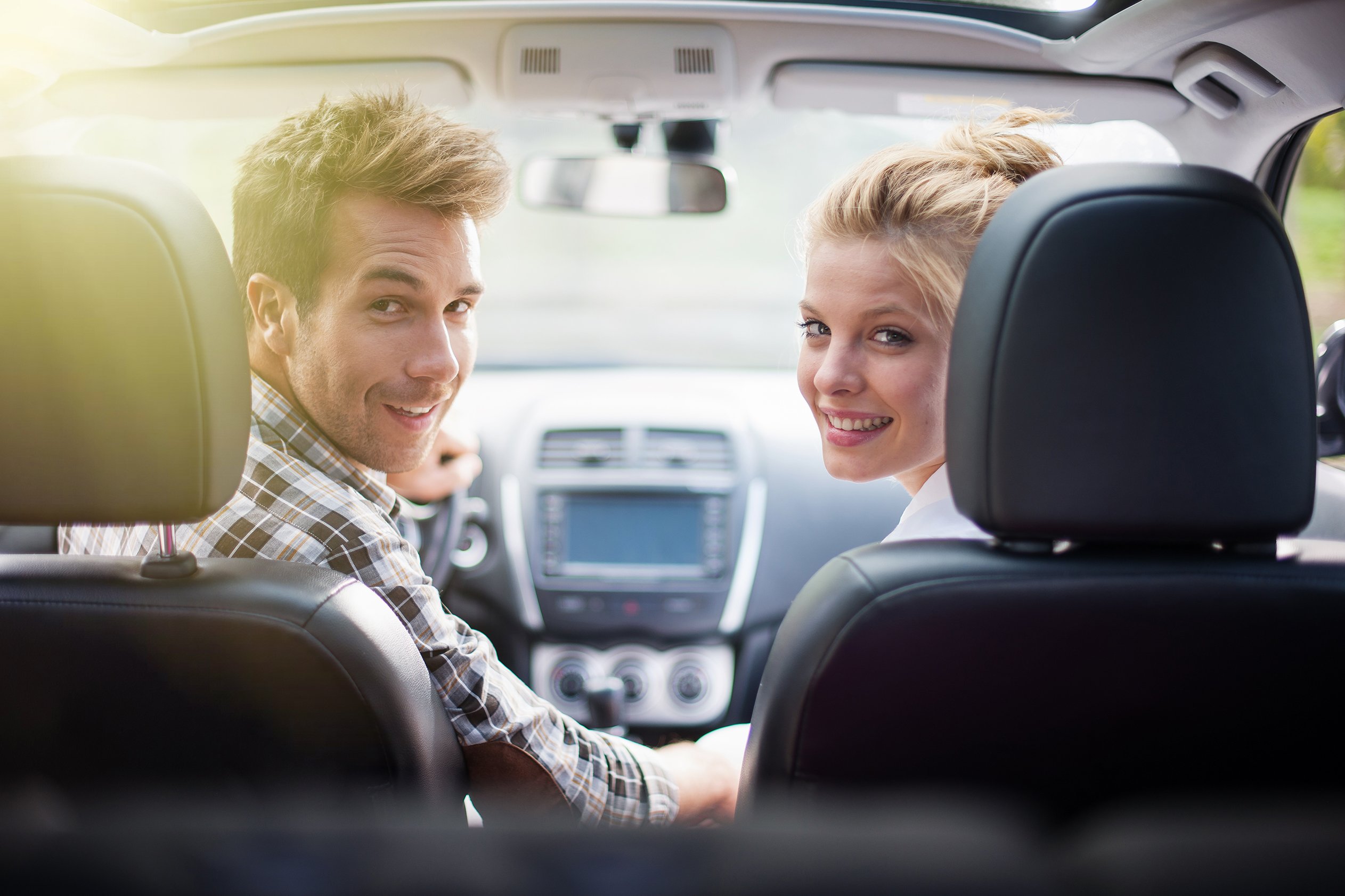 Couple looking into the back seat of a car